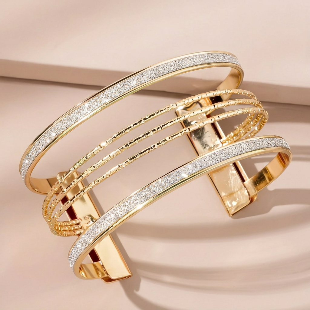 Gold-tone multi-row open bangle on a pale pink background